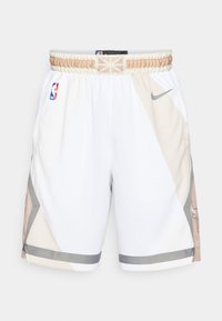 Hvite basketballshorts med beige og grå geometriske mønstre, elastisk midjebånd, sidelommer og NBA-logo på venstre side.