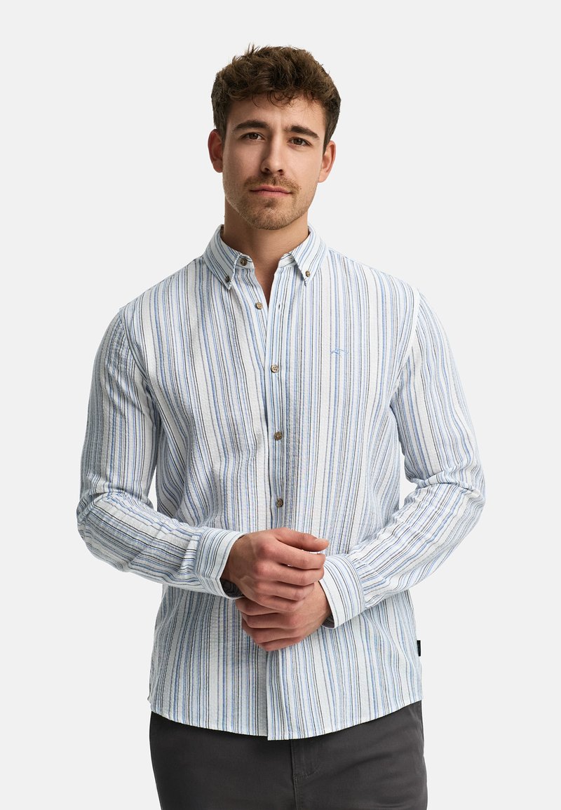 Camisa de botones en azul claro con rayas verticales. Presenta un cuello, mangas largas y un sutil detalle de logo cerca del pecho.