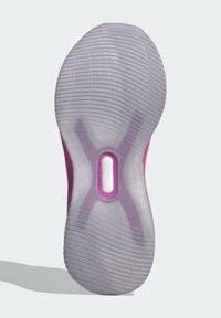 Podešev z průsvitné gumy s růžovými akcenty, která má vlnitý vzor tread a kruhový výřez pro flexibilitu a přilnavost.