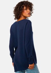 Navyblau gestrickter Pullover mit langen Ärmeln, entspannter Passform und Seitenschlitzen. weicher Stoff und minimalistisches Design, geeignet für den Freizeitlook.