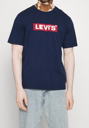 T-shirt en coton bleu marine avec un logo rectangulaire rouge et texte blanc "LEVI'S" sur le devant. Manches courtes et col rond.