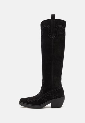 Schwarze Wildleder-Stiefel im Western-Stil in Knielänge mit spitzen Zehen, dekorativer Naht und einem klobigen Absatz. Verfügt über eine Zuglasche an der Rückseite.