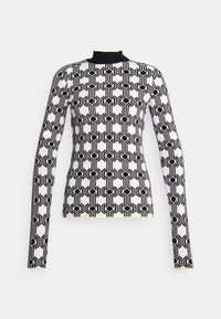 Top de manga larga en blanco y negro con un patrón geométrico de hexágonos, cuello alto y detalles amarillos en el dobladillo y los puños.