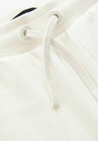 Cremefarvede sweatpants med ribbet talje, snøre med metaløjer og en blød, tekstureret stoffinish.