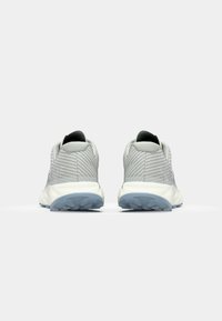 Gray athletic shoes with a textured mesh upper and a cushioned sole. Features minimalistic design and a light blue rubber outsole.