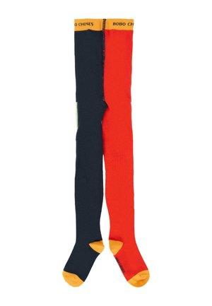 Calze colorate alte fino al ginocchio con un design diviso: un lato rosso e l'altro blu scuro, con dettagli gialli nella parte superiore e sulle punte. Texture morbida.