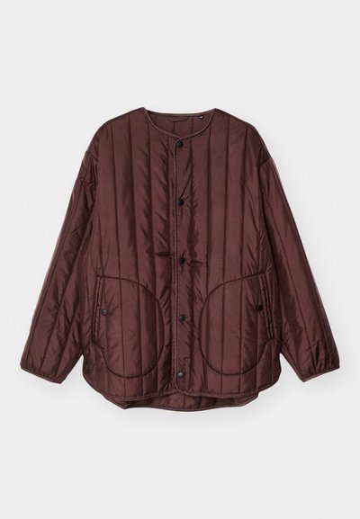 Brown quilted jacket with a round neckline, snap buttons, two large circular pockets, and textured vertical stitching throughout.