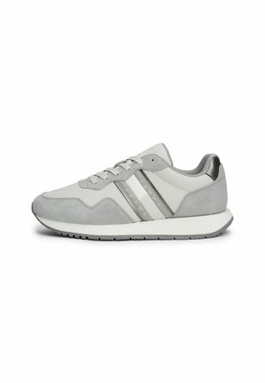 Zapatos deportivos grises que combinan ante y material sintético, con tres franjas horizontales y una entresuela blanca. Textura suave.