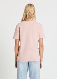 Hellrosa Baumwoll-T-Shirt mit kurzen Ärmeln, Rundhalsausschnitt und lockerer Passform. Sichtbare Nähte am Saum und leicht übergroßes Design.