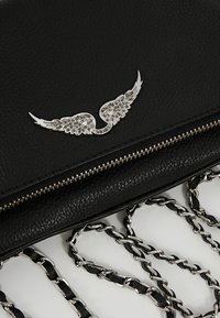 Clutch de cuero negro con un adorno plateado en forma de ala, con cierre de cremallera y correa de cadena con eslabones alternados.