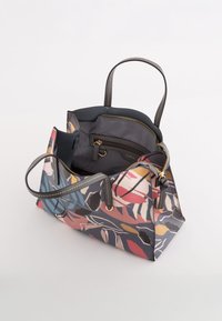 Farverig tote taske med blomsterprint på ydersiden, grå inderside, dobbelthåndtag og indvendige lynlåslommer. Har detaljer i guld-tone.