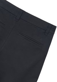 Pantaloni blu scuro con una texture liscia, due tasche posteriori e un logo del marchio discreto sulla vita. Design classico e su misura.