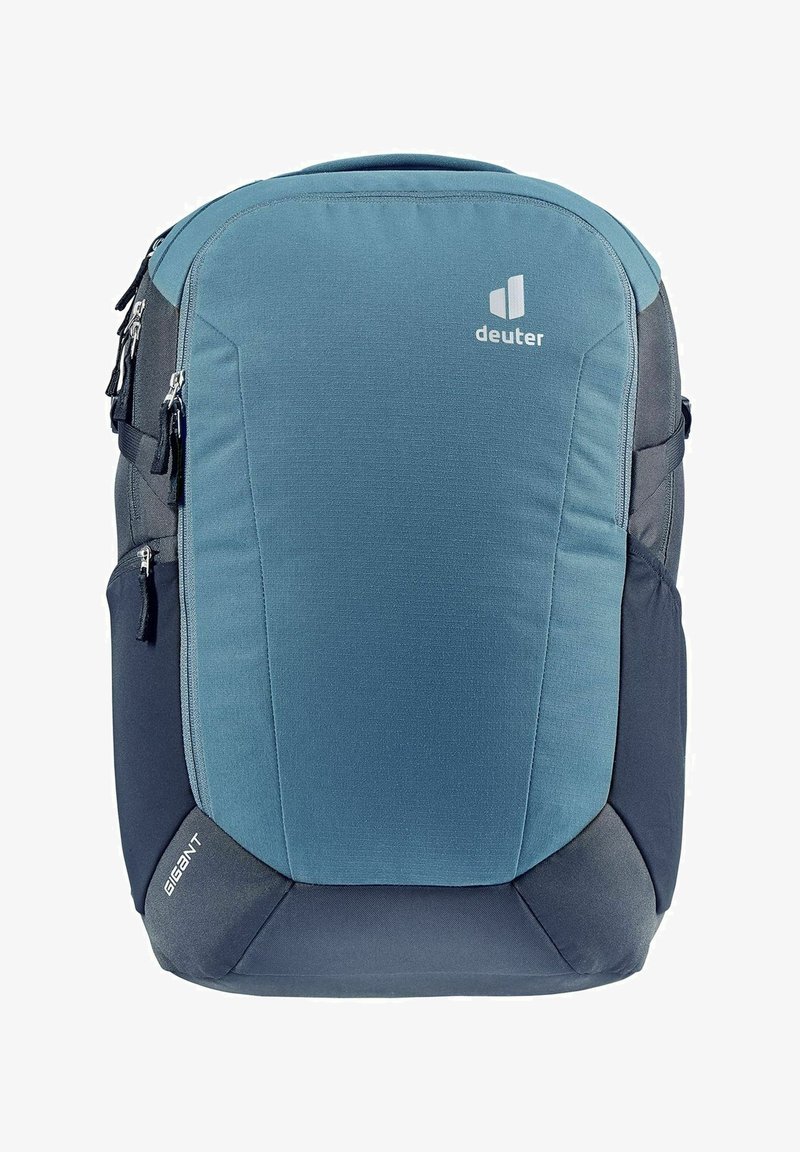 Mochila azul y gris con una textura de tela suave, forma acolchada, múltiples bolsillos con cremallera y un logo de marca en la parte frontal.