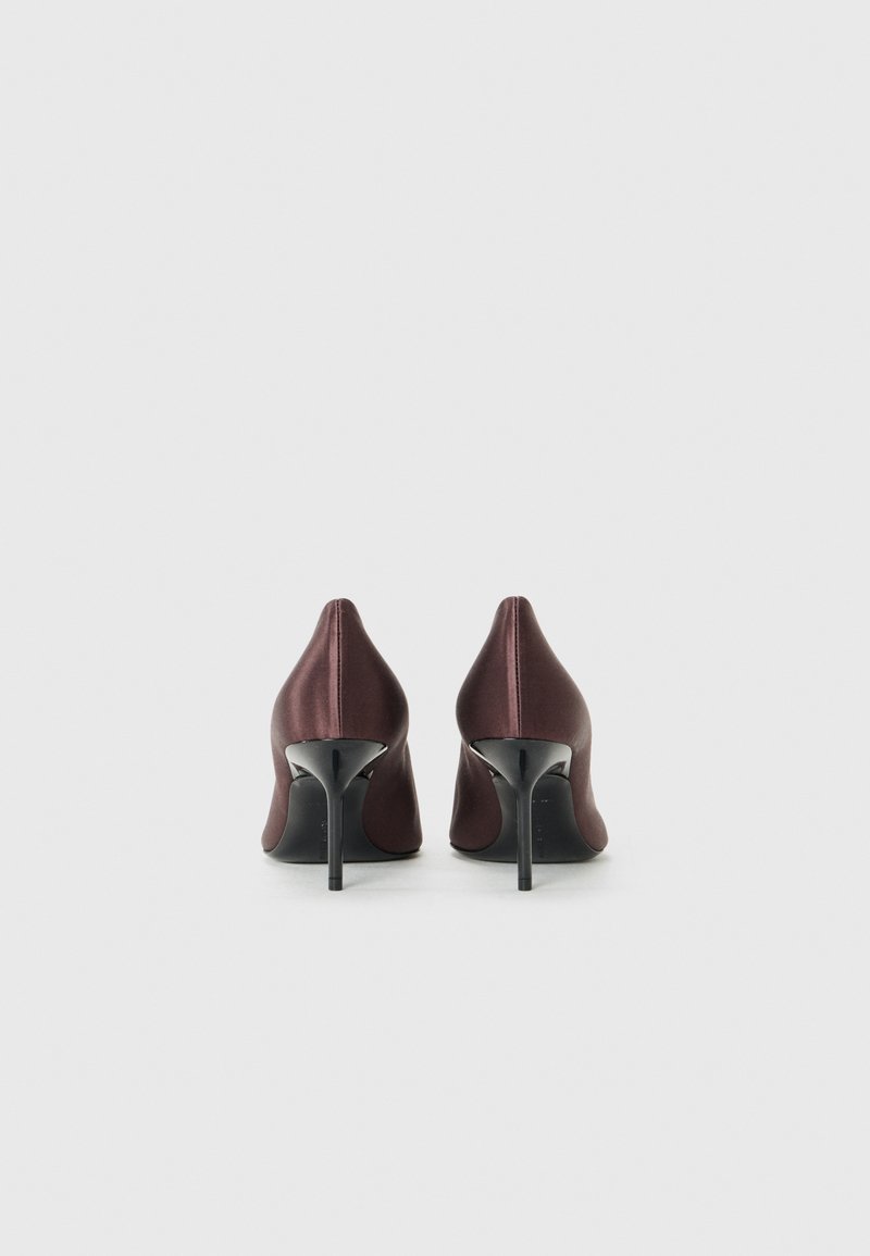 Burgunderfarvede satin højhælede sko med spids tå, der har en elegant stiletto-hæl og en glat tekstur, set fra bagsiden.