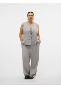 Grijze mouwloze top met striksluiting aan de voorkant, gecombineerd met losse grijze broek. Glad textuur, minimalistisch ontwerp, geen patronen of accenten zichtbaar.