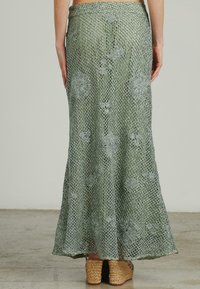 Gebreide maxi-jurk in het groen met bloemmotieven, voorzien van een gehaakte structuur en een vloeiende silhouette. Draag met tan wedgesandalen.