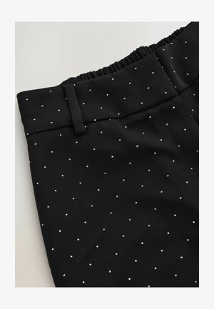 Pantaloni neri con cintura elastica, caratterizzati da un tessuto a trama e un piccolo motivo a pois argentati in tutto il tessuto.