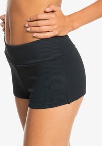 Sorte ribbede shorts med en bred linning, som har en tettsittende passform og jevn tekstur, designet for fleksibilitet og komfort.
