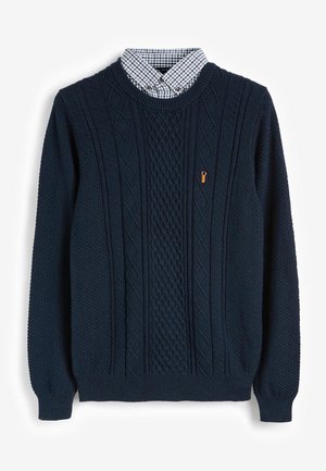 Pull en tricot bleu marine avec des motifs en câble, des poignets et un ourlet côtelés, doté d'un col avec un motif à carreaux noir et blanc en dessous.