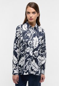 Long-sleeve button-up shirt in navy blue with white floral and leaf pattern, collared, smooth fabric, featuring a fitted design.