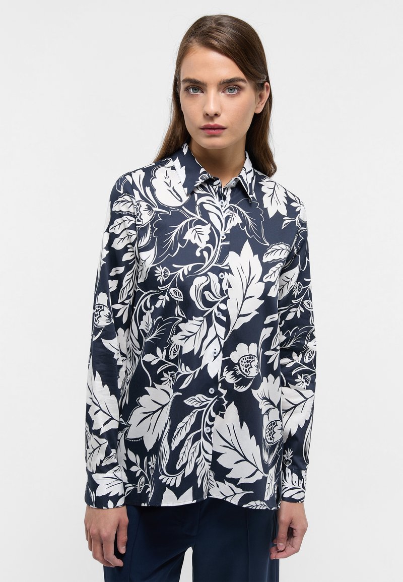Long-sleeve button-up shirt in navy blue with white floral and leaf pattern, collared, smooth fabric, featuring a fitted design.