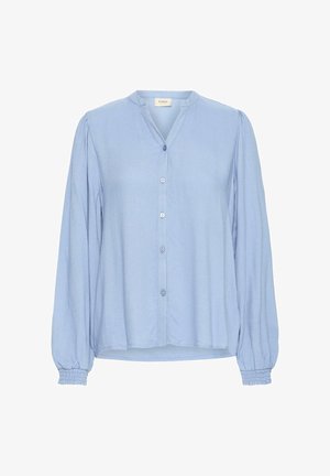 Svetlo modra bluza z dolgimi rokavi, z ovratnikom v obliki črke V, sprednjim gumbom in nabrano obdelavo na manšetah rokavov. Mehek, teksturiran material.