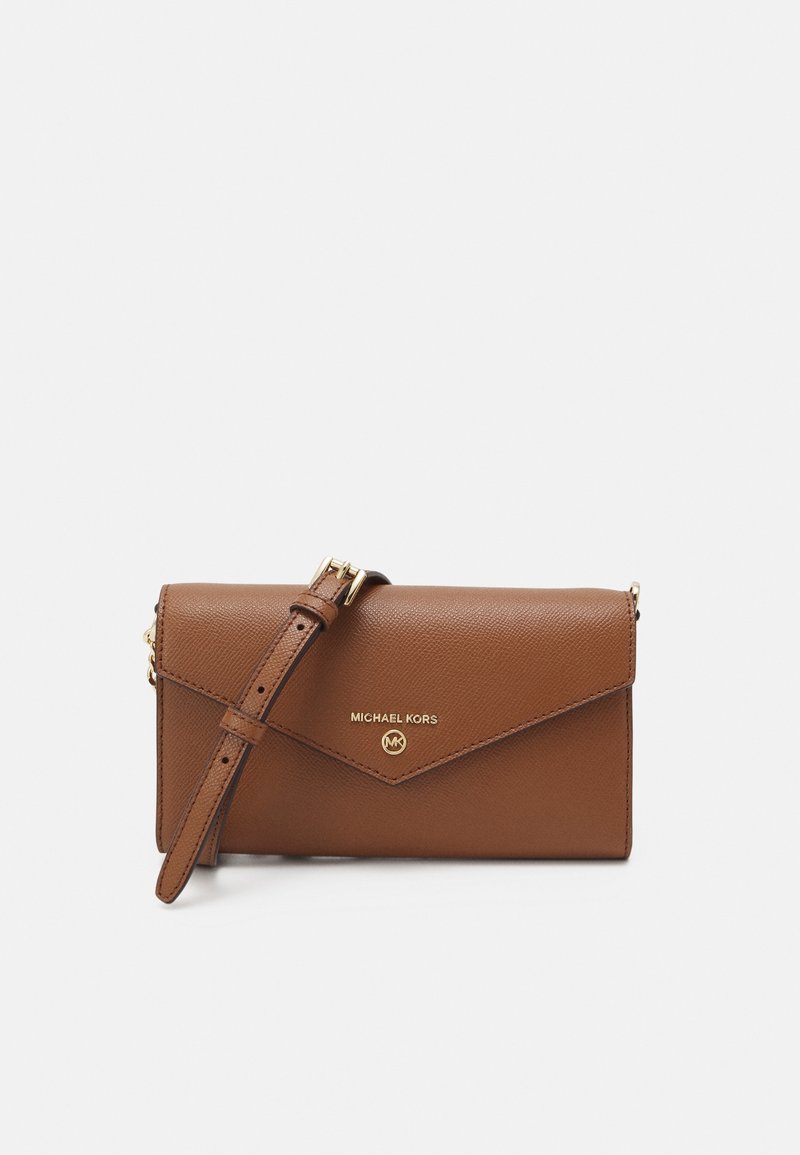 Sac bandoulière en cuir marron Michael Kors avec sangle réglable et logo doré sur le rabat avant sur fond blanc.