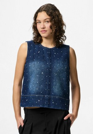 Top sans manches en denim bleu foncé avec de petites clous métalliques éparpillés. Coupe boxy, encolure ronde et ourlet brut.