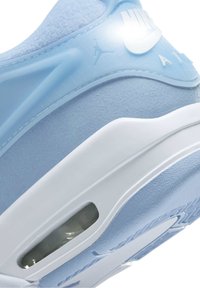Talons de sneaker Nike Air bleu clair et blanc avec coussinet d'air visible et logo Jumpman sur le panneau latéral.