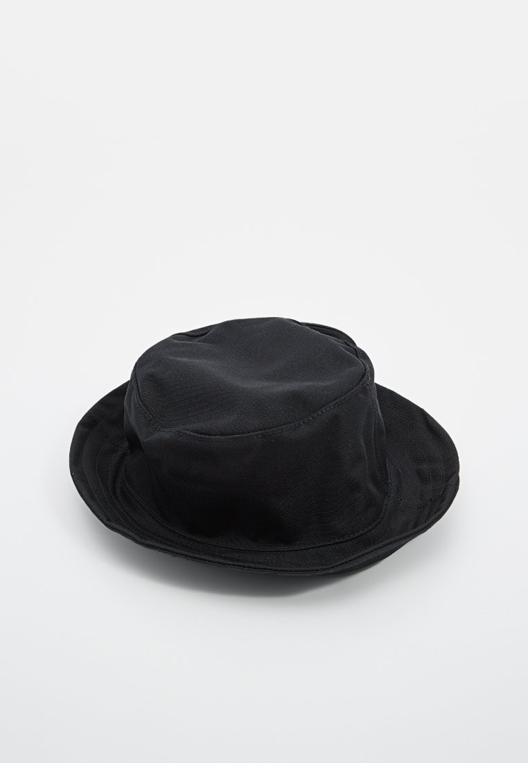 Chapeau de seau noir en tissu texturé avec une couronne ronde et un large bord flasque. Pas de matériel ou d'accents visibles.