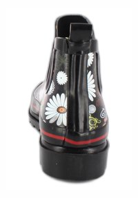 Schwarze Gummistiefelette mit einem floralen Muster in Weiß und Gelb. Sie hat einen roten Streifen an der Sohle und eine Zuglasche hinten für ein einfaches Anziehen.
