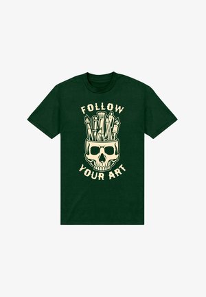 T-shirt in cotone verde scuro con un design di teschio crema riempito di materiali artistici e il testo "SEGUITA IL TUO ARTE" in caratteri in grassetto.
