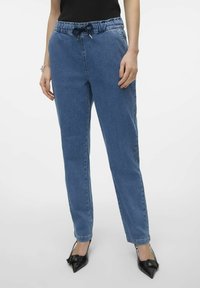 Denim joggeri u svijetloplavoj boji, sa elastičnim pojasom i vezicom, ravnim nogavicama i bočnim džepovima. Glatka tekstura tkanine.