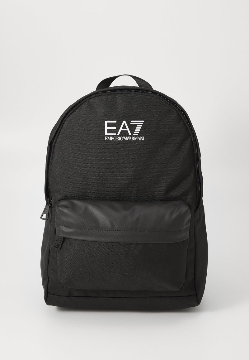 Sac à dos noir avec une poche avant zippée et le logo EA7 Emporio Armani en blanc, présenté sur un fond blanc uni.