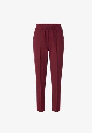 Burgunderfarbene Jogginghose mit elastischem Bund, Kordelzug und seitlichen Taschen. Glatte Textur, schmal zulaufende Beine und minimalistisches Design.