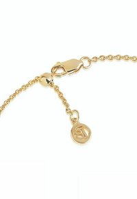 Guldkedjearmband med spänne, med en rund berlock präglad med initialer. Länkdesignen är delikat och visar en polerad yta.