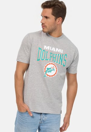 Camiseta de algodón gris con el texto en negrita "Miami Dolphins" en turquesa y blanco. Gráfico de delfines en un diseño circular con acentos naranjas.