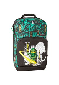 Sac à dos noir avec motifs de ninjas verts, une poche frontale ornée d'un graphisme de ninja, et des accents jaunes. Compartiments zippés et poignée robuste inclus.