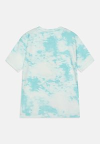 Camiseta de manga corta con patrón de teñido anudado en azul y blanco, mostrada plana sobre un fondo blanco, mostrando el reverso.