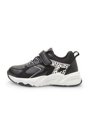 Czarno-białe dziecięce sneakersy z paskiem na rzep, detalami sznurowania i wzorem w cętki po boku, z białą masywną podeszwą.