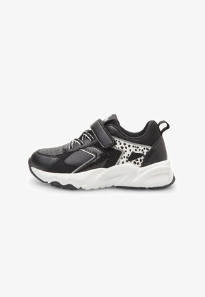 Czarno-białe dziecięce sneakersy z paskiem na rzep, detalami sznurowania i wzorem w cętki po boku, z białą masywną podeszwą.