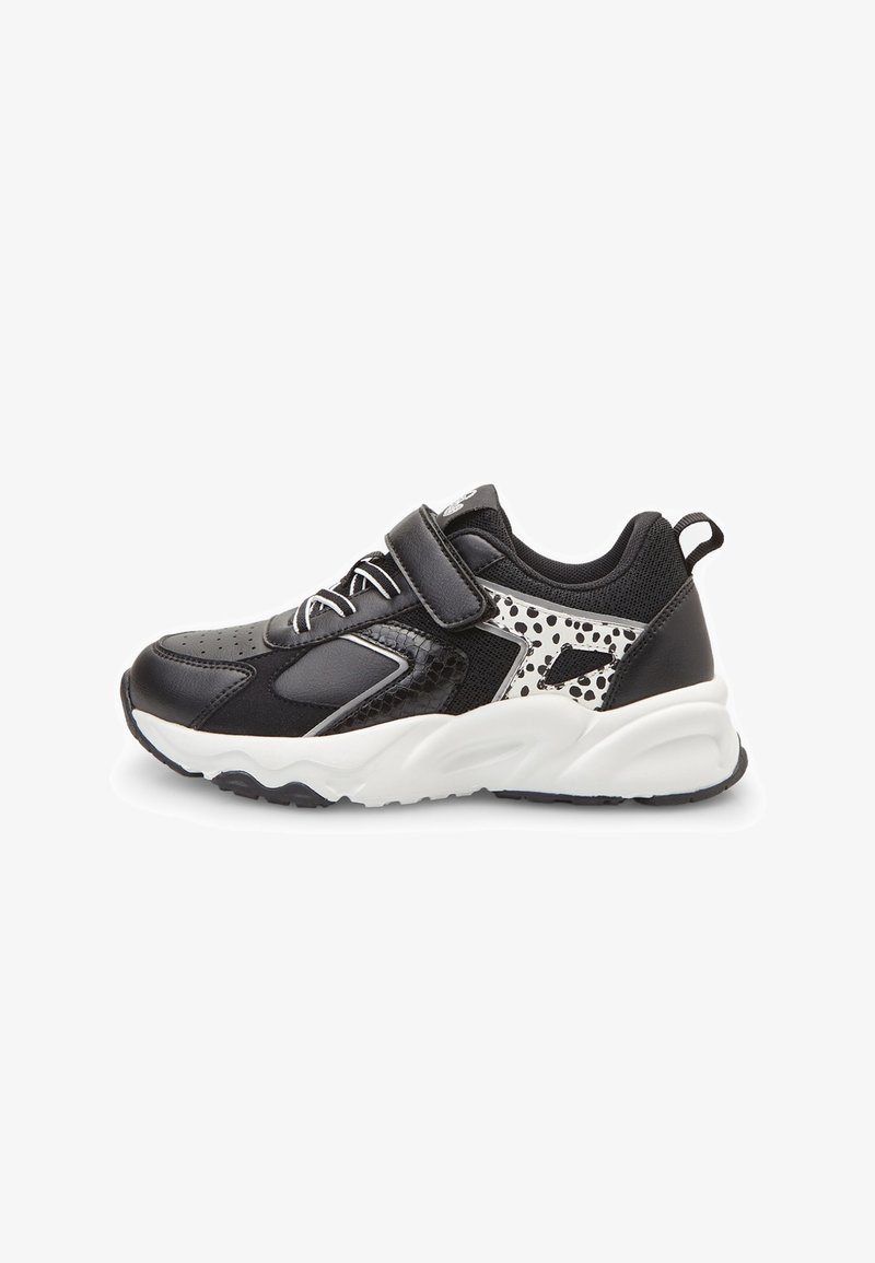 Baskets enfants noir et blanc avec bride velcro, détails lacets et motif tacheté sur le côté, avec une semelle blanche épaisse.