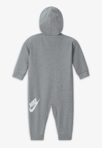 Siv meira-oblačila z dolgimi rokavi, kapuco in zapenjalnimi hlačnicami. Vsebuje bel Nike logotip na spodnjem levem delu noge.