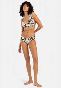 Zweiteiliges Bikini-Set mit floralem Muster in Pastellfarben auf dunklem Hintergrund. Das Oberteil hat einen tiefen V-Ausschnitt und der Slip sitzt tief auf der Hüfte.