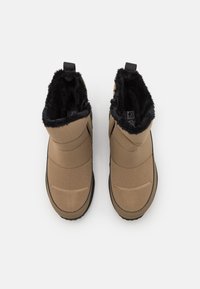 Bruna isolerade stövlar med en mjuk svart pälsfoder, slät texturerad ovandel och gummisula; designade för värme och komfort.