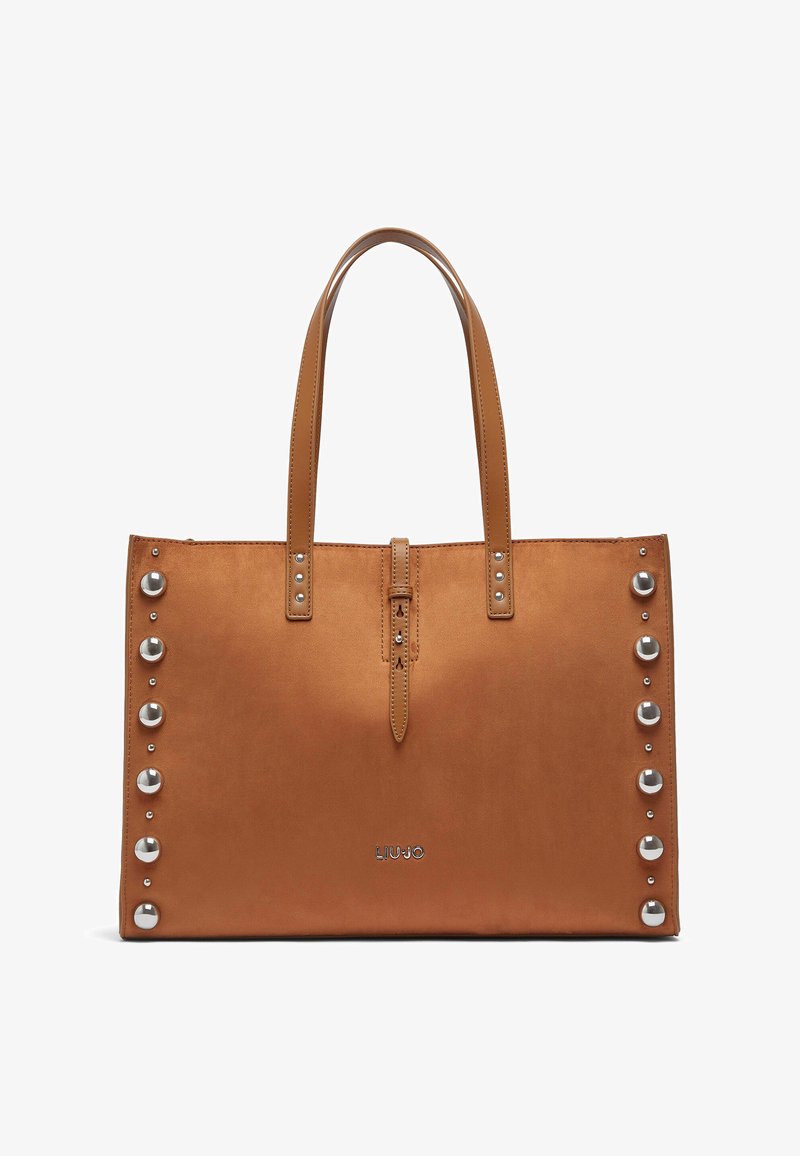 Sac cabas synthétique marron avec deux anses, orné de clous argentés le long d'un côté et d'une fermeture éclair centrale. Logo en bas.