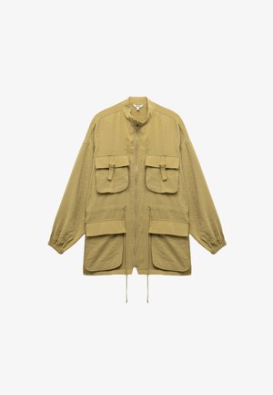 Jasno oliwkowa kurtka z zamkiem z przodu, stójką, dwiema dużymi kieszeniami na piersi oraz dwiema dolnymi kieszeniami z elastycznymi mankietami.