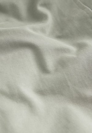 Světle zelená látka s jemnou, hladkou texturou, která má subtilní záhyby a jemný tkaný vzor. Ideální pro různé textilie a oděvy.