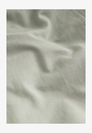 Light green fabric with a soft, smooth texture, featuring subtle creases and a fine woven pattern. Ideal for various textiles and garments.