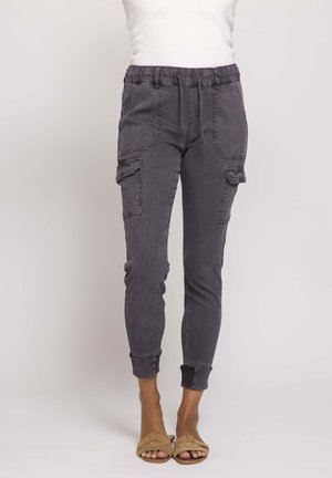 Schlanke Cargo-Hosen in Kohlegrau mit elastischem Bund, Seitentaschen und gekrempelten Bündchen, getragen mit sandfarbenen Sandalen mit offenem Zehenbereich.